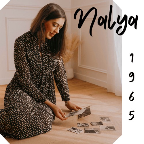 Pochette du titre "1965" de Nalya. on voit en haut droite le nom "Nalya". Sur la droite à la verticla, dans un cadre blanc, le titre "1965". Le reste de la pochette est occupée par Nalya, assise par terre, qui regarde des photos au sol, elle en a une dans chaque main.