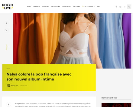 Capture d'écran d'un article du site Pozzo Live intitulé : 'Nalya colore la pop française avec son nouvel album intime'. L'image montre une femme souriante, vêtue d'une robe blanche à bretelles fines, se tenant devant un fond coloré avec des rideaux aux tons orange, bleu, violet et jaune. Le titre de l'article est affiché sur un fond jaune vif, avec le logo de Pozzo Live en bas à gauche.
